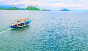 Traditional blue boat on Lake Kivu with islands and hills. Ebenezer hotel apartments 